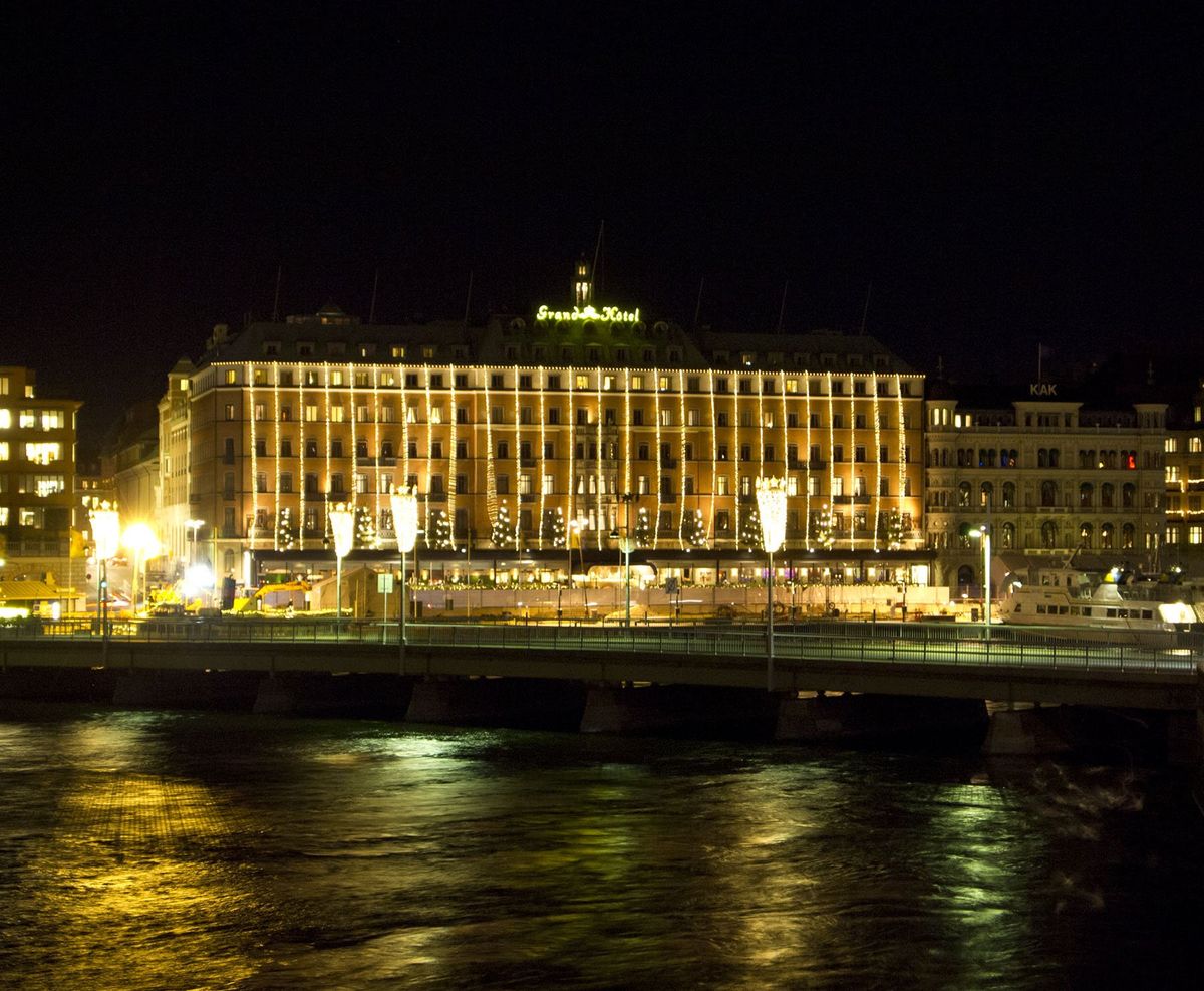Grand Hôtel Stockholm bei Nacht, beleuchtete Fassade am Wasser