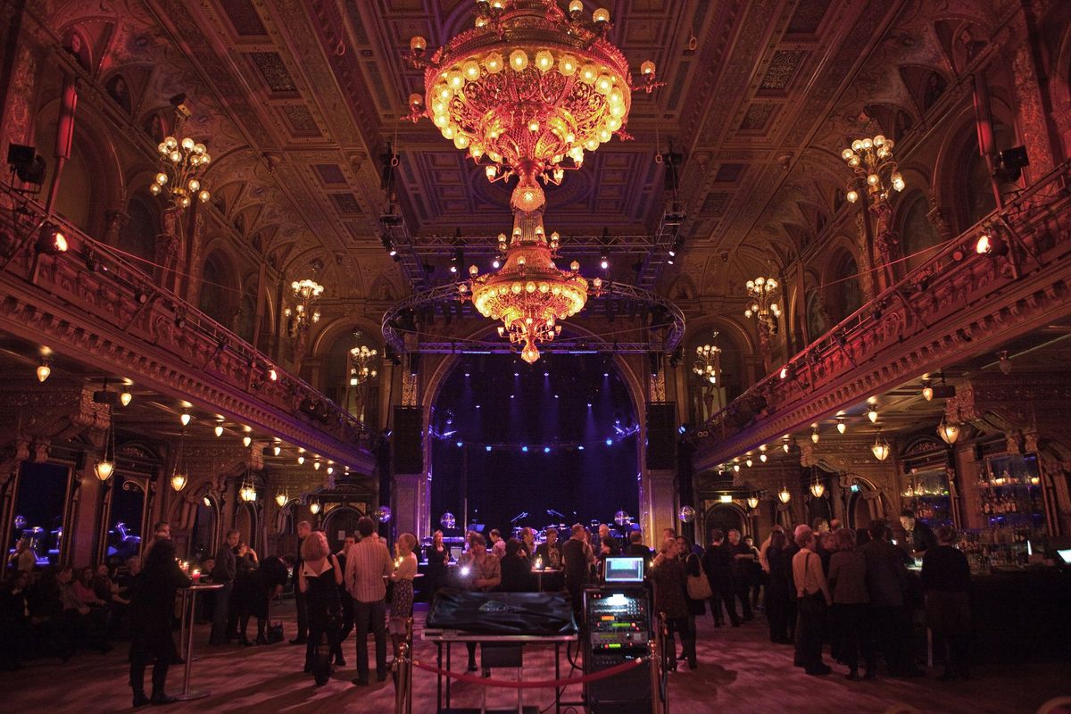 Festsaal des Berns in Stockholm mit Kronleuchtern und Publikum